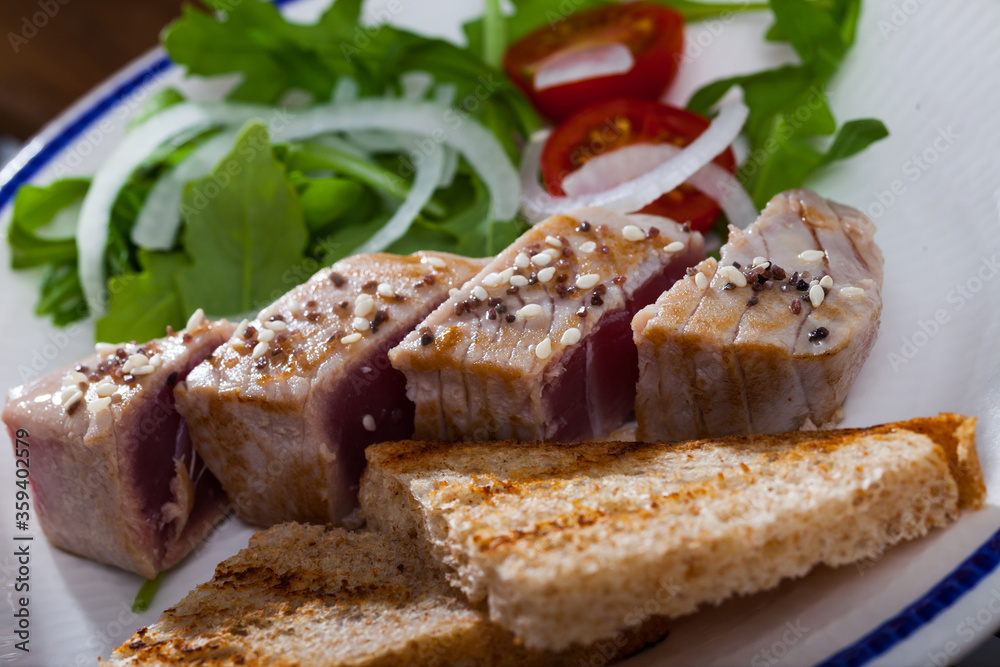 Seared tuna steaks with greens and grilled bread