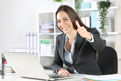 Photography Happy executive with thumbs up looking camera at office
