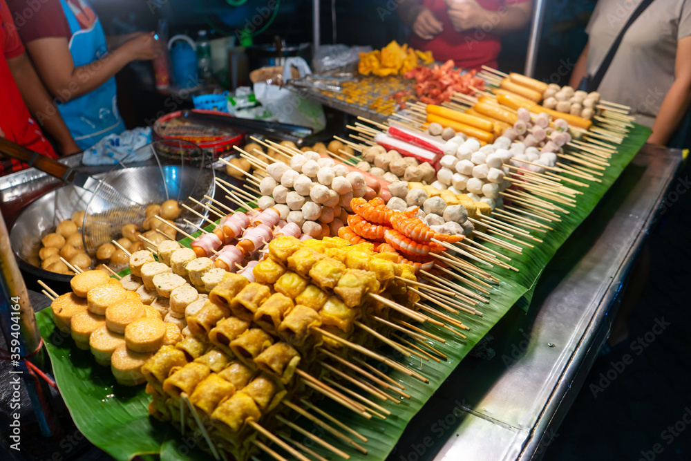 Asian food. Different mini barbecue counter at night street food market.