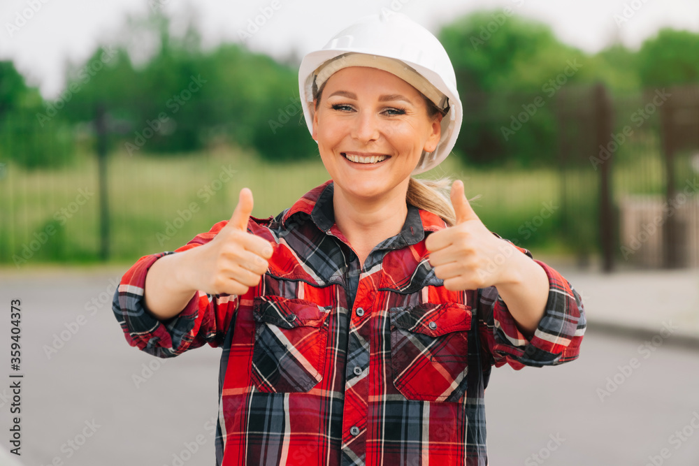 Cheerful woman architect builder is showing hands a sign of good quality.