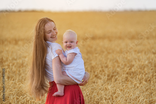 Young mother and child walking on field and fun smile. Mother holding little daughter outdoors © somemeans