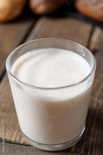 Probiotic cold fermented dairy drink kefir on wooden background.