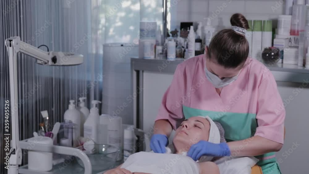 Professional beautician washes the mask off the face of a woman. Professional beautician washes the mask off the face of a woman.
