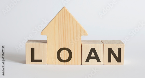 Wooden blocks with the word LOAN , house. The concept of the high cost of rent for an apartment or home. Interest rates are rising. Real estate market.