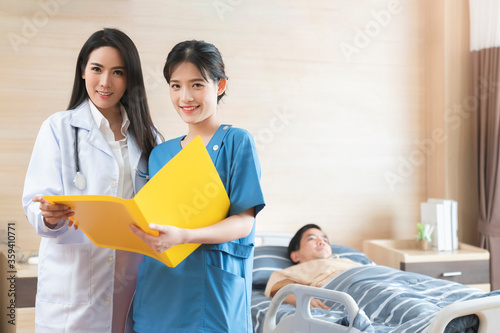 Portrait of smiling doctors standing together on the ward room Checking patient records on a file chart health and ideas concept photo