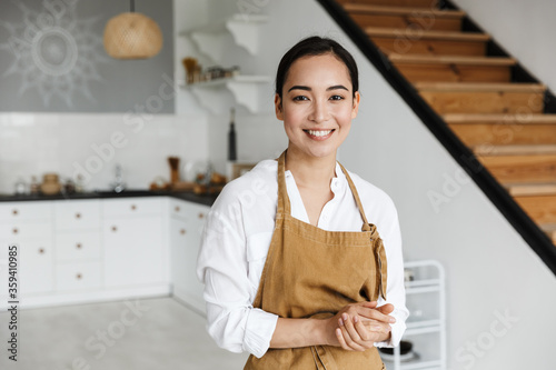 Fotomurale Smiling attractive young asian woman wearing apron