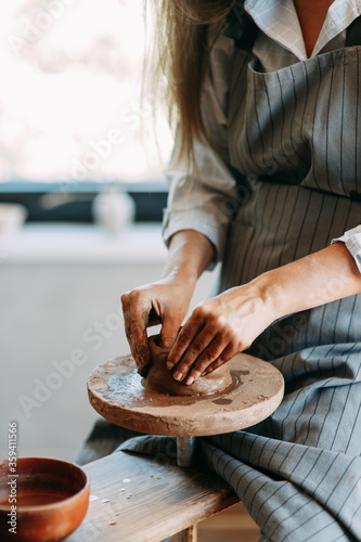 Hands of a girl on a Potter's wheel with clay. The process of creating pottery. photo