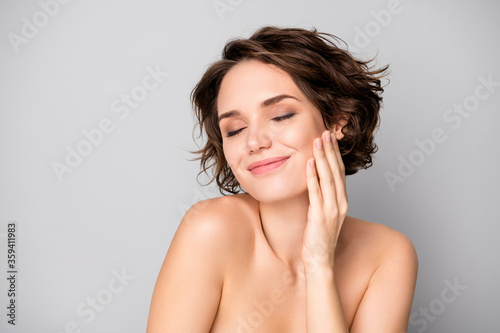 Portrait of positive lovely pretty girl touch hand face enjoy her soft pure perfect skin after bodycare plastic surgery treatment isolated over grey color background