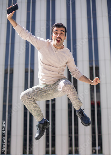 Joven exitoso en el entorno laboral muy feliz saltando para celebrar un ascenso en el trabajo photo