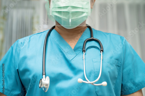 Asian doctor wearing face shield and PPE suit to check patient protect safety infection Covid-19 Coronavirus outbreak at quarantine nursing hospital ward. © amazing studio