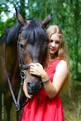 outdoor portrait of young beautiful woman with horse. Against the background of a tree © Владимир Лис