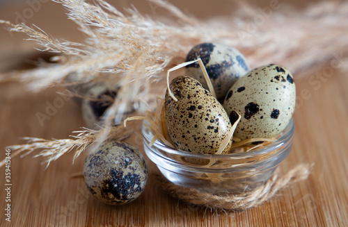 
quail eggs on a light beige background on a wooden board