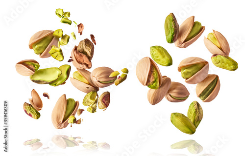 A set with Flying in air fresh raw whole and cracked pistachios  isolated on white background. Concept of Pistachios is torn to pieces close-up. High resolution image photo