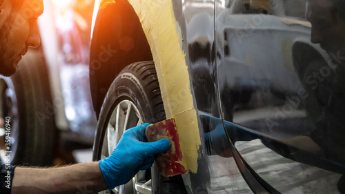 Schilderij op canvas Auto mechanic working on car paint sanding in mechanics garage
