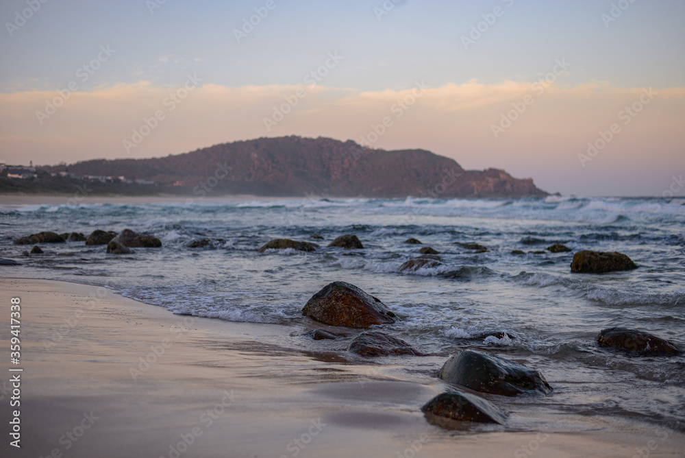 Fototapeta premium Boomerang Beach sunset looking over the ocean towards the hills