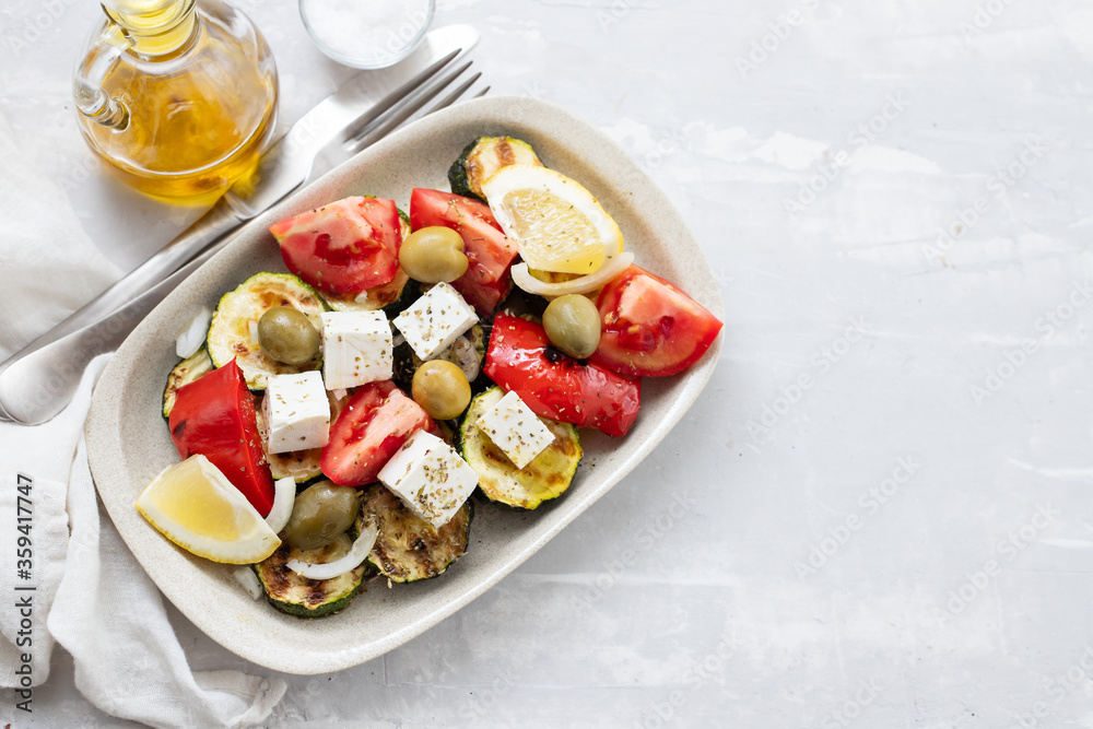 salad with fresh and grilled salad on white dish on gray ceramic background