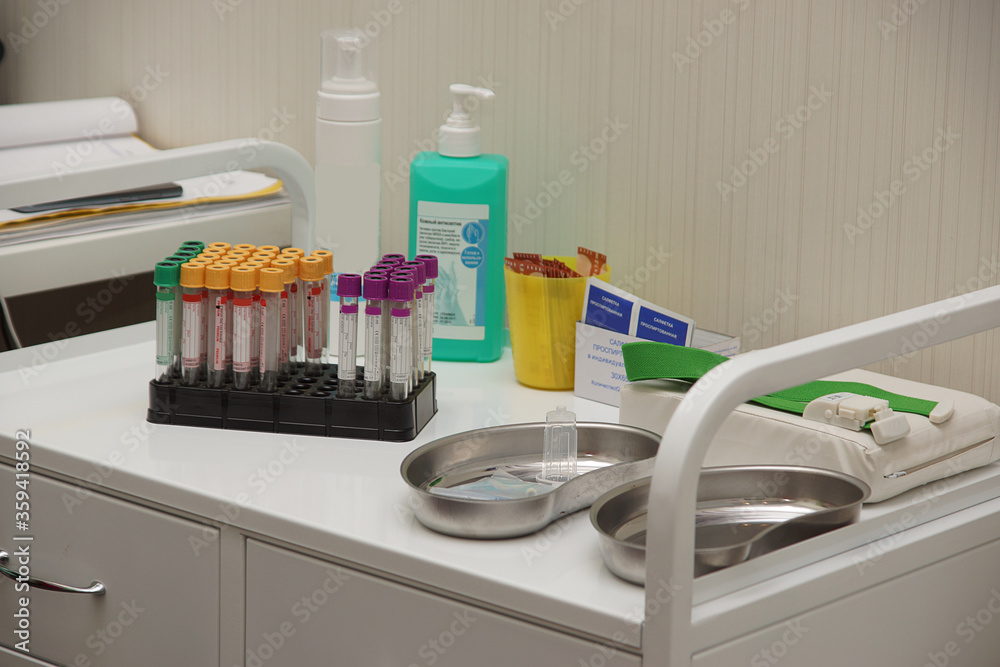 A table in the doctors office with many disinfectants and a set of test tubes