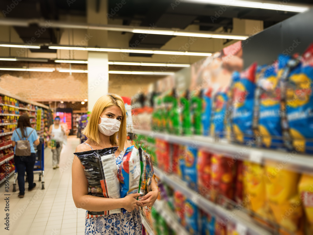 Beautiful girl buys potato chips during covid19 outbreak
