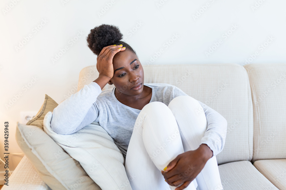 People, emotions, stress and health care concept - unhappy african american young woman touching her head and suffering from headache