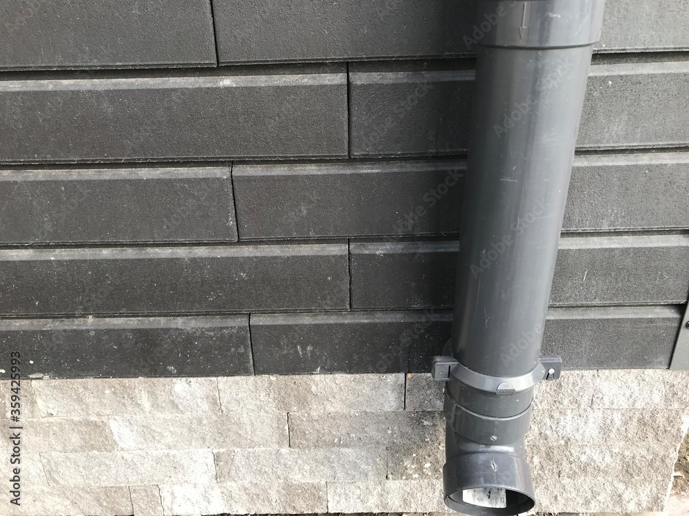 water pipe against the background of a black wall and gray tiles water pipe against the background of a black wall and gray tiles