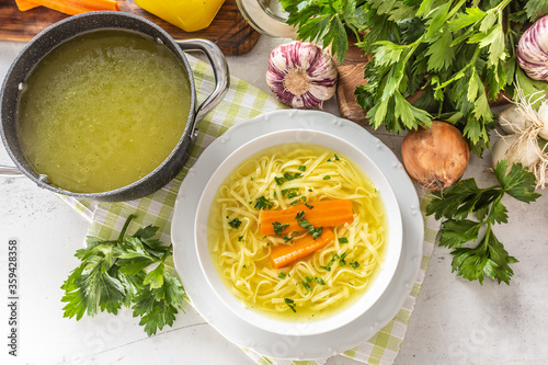 Photos Chicken soup broth in a plate carrot onion celery herbs garlic and fresh vegetab
