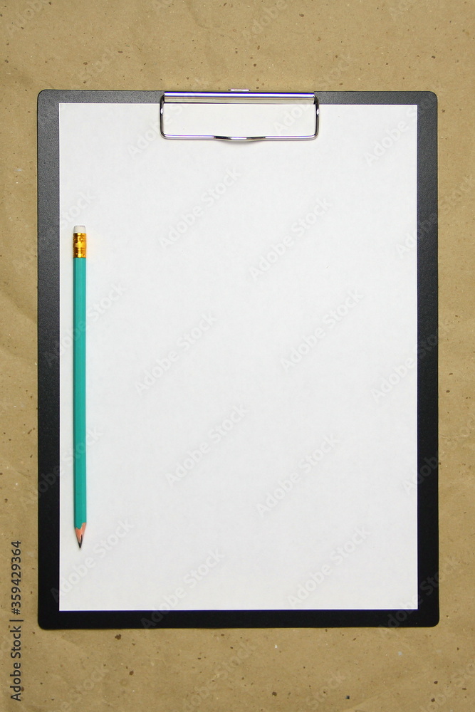 A tablet with a white sheet of A4 format with pencil on a beige craft paper. Concept of new opportunities, ideas, undertakings, innovations. Stock photo with empty place for your text and design. A tablet with a white sheet of A4 format with pencil on a beige craft paper. Concept of new opportunities, ideas, undertakings, innovations. Stock photo with empty place for your text and design.