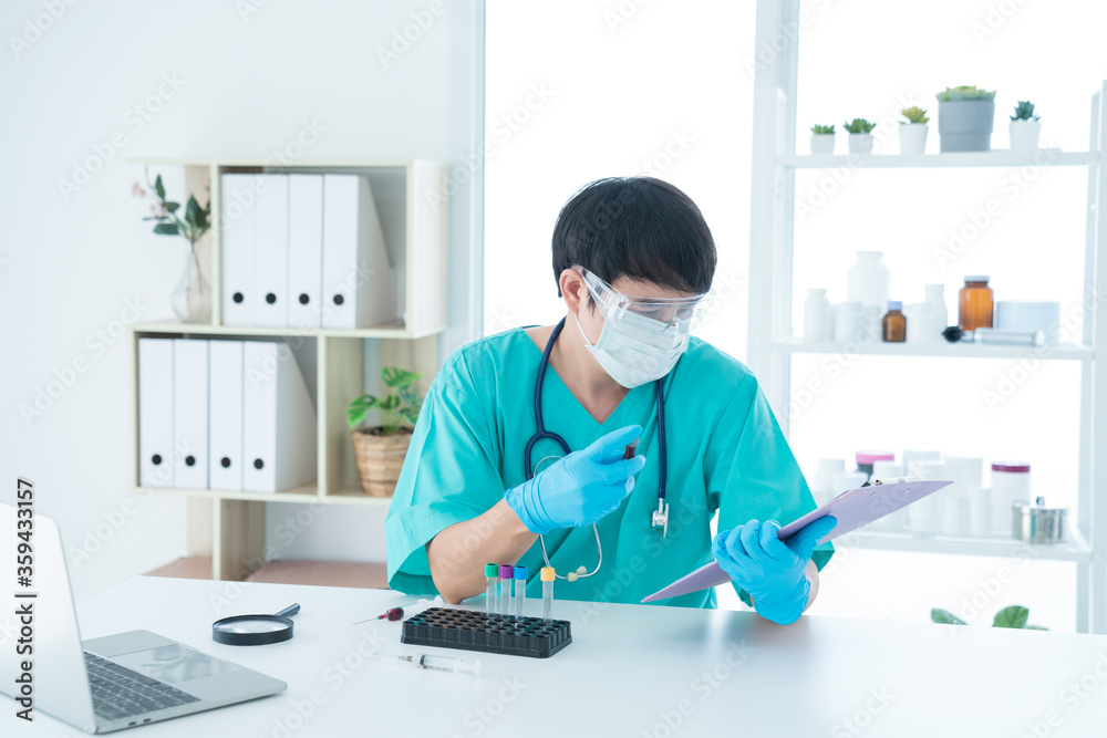 The male doctor is analyzing the blood results from the documents. The doctor is working hard on the blood in the lab. Doctor Hand holding Disease analysis results.