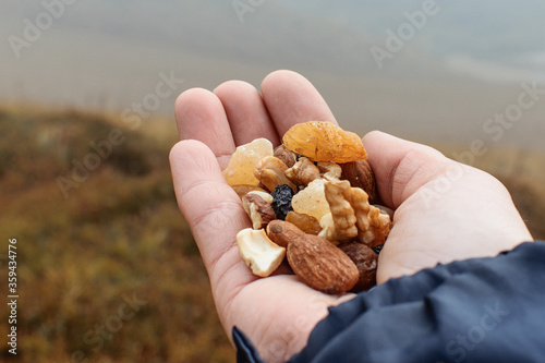 Obraz na plátně Hand with nuts and dried fruits during the trek.