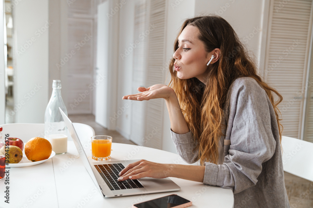 Portrait of woman blowing air kiss while making video call on laptop Portrait of woman blowing air kiss while making video call on laptop