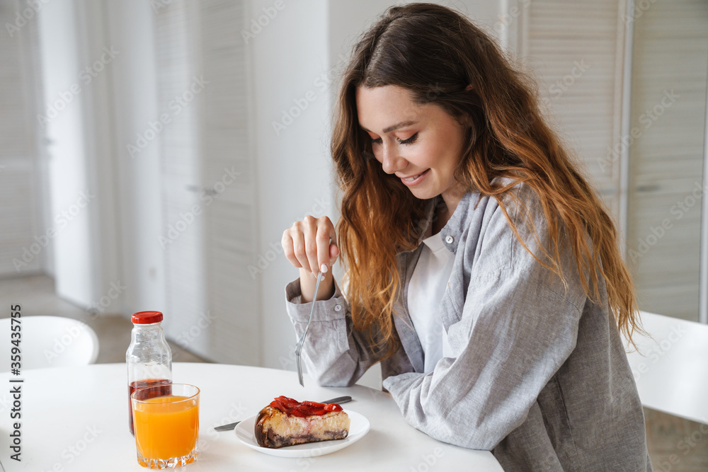 Photo of funny beautiful caucasian woman smiling while having breakfast Photo of funny beautiful caucasian woman smiling while having breakfast