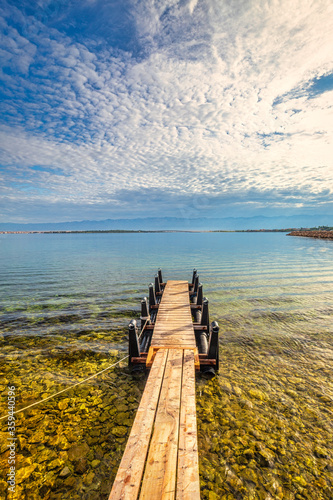 Fototapeta Naklejka Na Ścianę i Meble -  Sea landscape with small wooden pier for boats. View from Privlaka village in the Zadar County of Croatia, Europe.