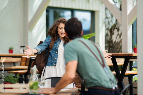 Happy couple greeting outdoors on terrace restaurant, end of lockdown.