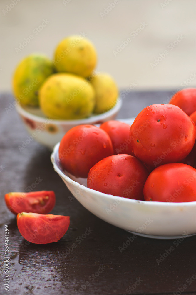 Red organic tomatoes and limes in blurry background Red organic tomatoes and limes in blurry background