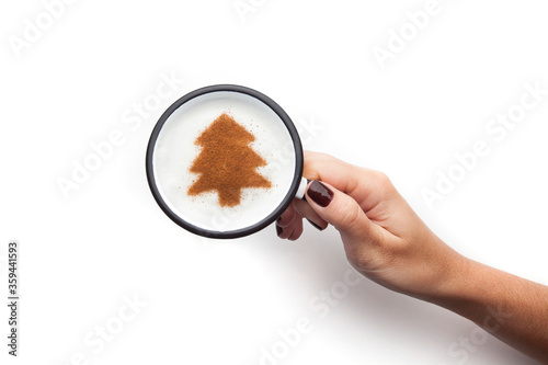 A rustic mug with coffee cream. Food art creative concept image, drawing with cinnamon powder over milk cream in a white background.