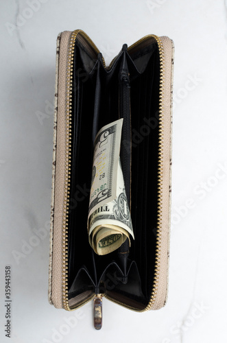 Top view of opened female purse and cash in it on the white surface.Vertical image photo