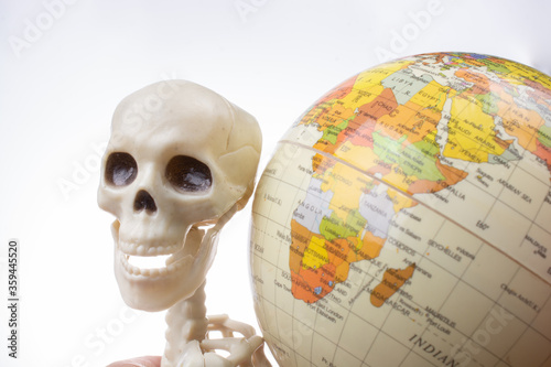 Skeleton with a globe in hands photo