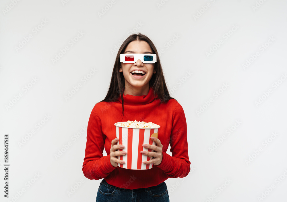 Photo of brunette woman wearing 3D glasses holding popcorn bucket Photo of brunette woman wearing 3D glasses holding popcorn bucket