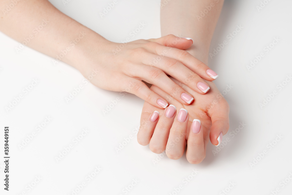 Fototapeta premium Well-groomed female hands with manicure on white background