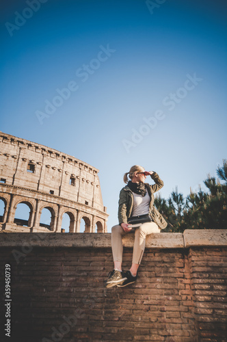 Beautiful girl at autumn sunset in front of the Colosseum in Rome, Italy