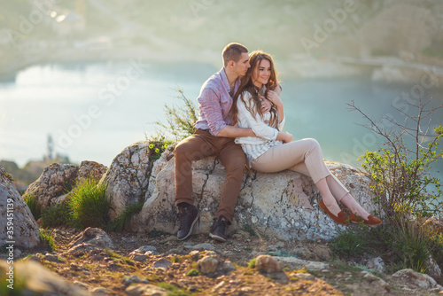 Young couple in love outdoor.Stunning sensual outdoor portrait of young stylish fashion couple posing on the background of mountains and sea