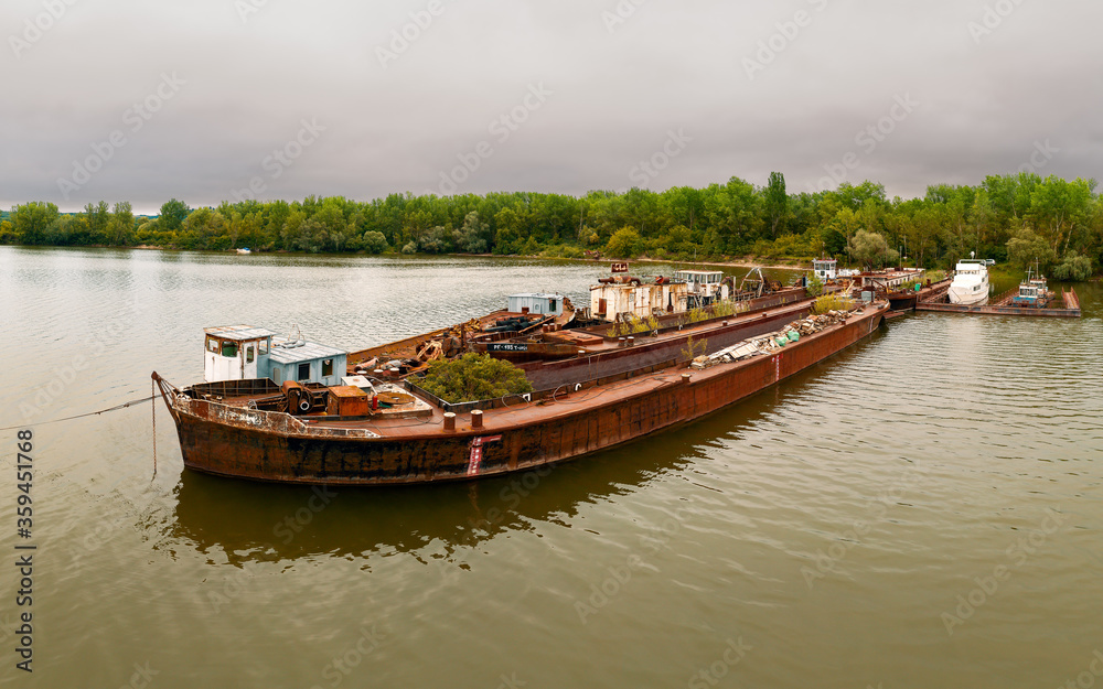 Rusted shipwrecks in Danube bend. Ship cementery next to Pilismarot city in Hungary. Old useless industrial ships pollute the environment