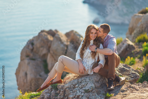 Young couple in love outdoor.Stunning sensual outdoor portrait of young stylish fashion couple posing on the background of mountains and sea