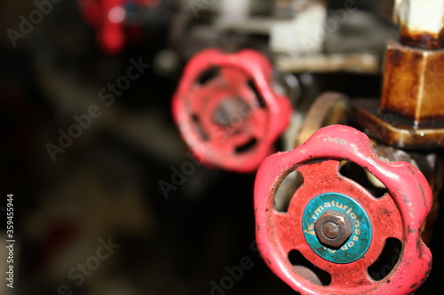 Red fuel valve (stop cock) handles on big industrial marine ship diesel engine