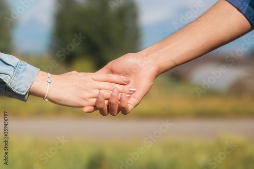 Lovers couple holding hands in a summer forest