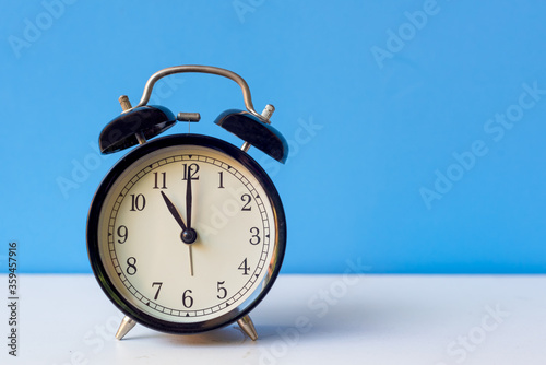 Alarm black vintage alarm clock falling on the floor with color background