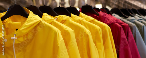 Canvas Print Bright colorful autumn raincoats hanging at a fashion store