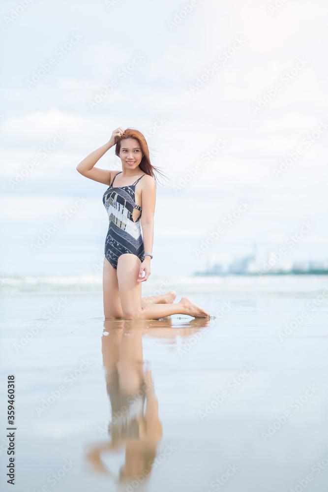 Naklejka premium young woman sitting on beach, travel on holidays, girl enjoying at summer. relax on beach. happy time, vocation 