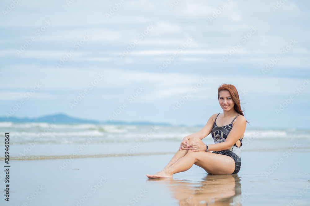 young woman sitting on beach, travel on holidays, girl enjoying at summer. relax on beach. happy time, vocation
