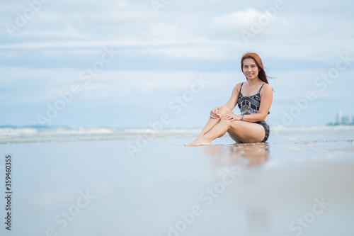 young woman sitting on beach, travel on holidays, girl enjoying at summer. relax on beach. happy time, vocation 