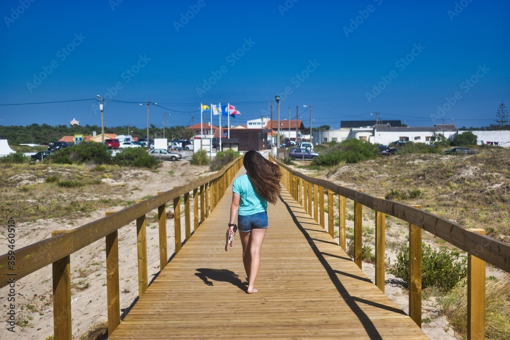 woman walking on a boardwalk woman walking on a boardwalk